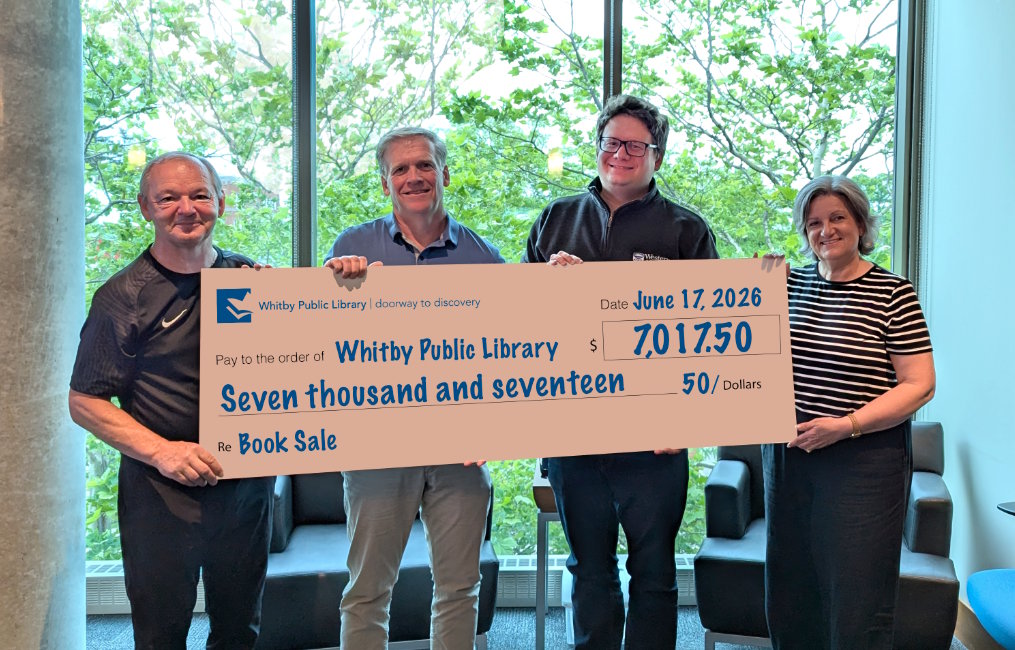 Four people holding a big cheque.
