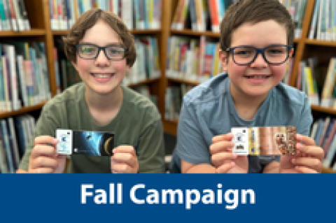 Two boys holding their library card