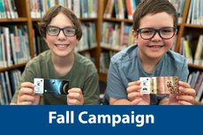 Two boys holding their library card